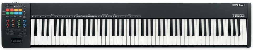Full-length black and white MIDI keyboard controller with colored pads, knobs, buttons, and two levers on the left side.