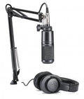 Black microphone on adjustable arm stand and pair of black over-ear headphones on white background