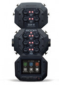 Black audio mixer device with multiple rotary knobs, push buttons, and a touchscreen display showing app icons.