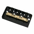 Black metal guitar bridge baseplate with four adjustable brass saddles and screws.