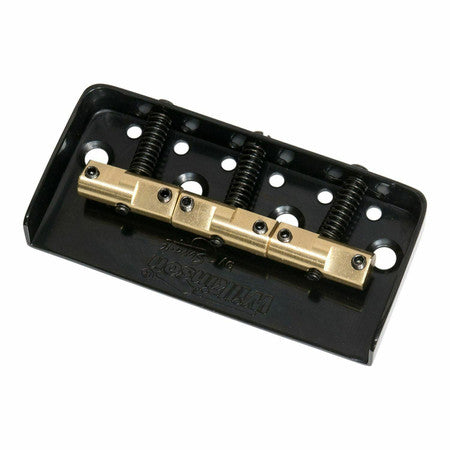 Black metal guitar bridge baseplate with four adjustable brass saddles and screws.