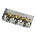 Chrome metal guitar bridge with brass saddles and Wilkinson branding on top.