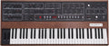 Front view of a Prophet-5 synthesizer with knobs, switches, buttons, a keyboard, and wooden side panels.