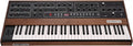 Keyboard synthesizer with wooden side panels and multiple knobs, buttons, and pitch/mod wheels on top control panel.