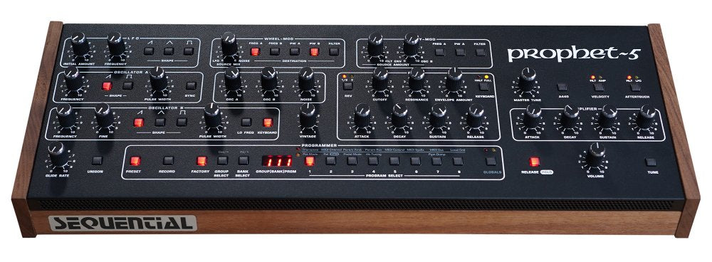 Top view of a Sequential Prophet-5 synthesizer desktop module with knobs, buttons, and wood side panels.