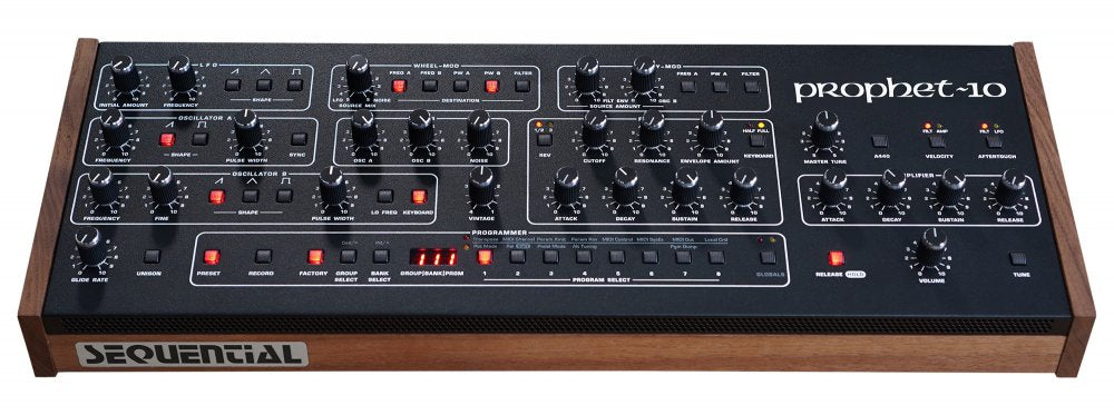 Black desktop synthesizer module with wood side panels and various knobs, buttons, and sliders labeled prophet-10.