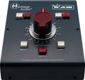 Black audio monitoring controller with large red rotary knob and multiple white and red buttons on top panel.