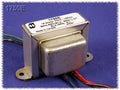 Metal output transformer with multiple colored insulated wire leads on a blue cloth background.
