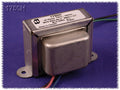 Metal transformer with wire leads and mounting flanges labeled 1750H and technical specifications on a white sticker.