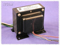Black rectangular output transformer with four colored wire leads on a purple background.