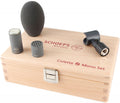 Microphone components including capsule, body, foam windscreen, mount clip on a wooden box with red lettering.