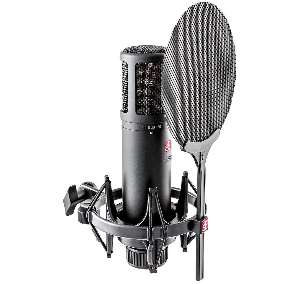 Black studio microphone with shock mount and round mesh pop filter on a white background.