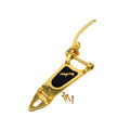 Gold-colored vibrato tailpiece with black logo plate and three screws displayed on a white background.