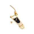 Gold-colored vibrato tailpiece with lever and four screws on a white background.