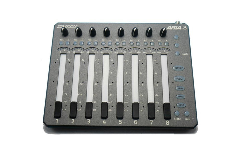 Top-down view of a ZAXCOM Aria-8 audio mixer with eight channel sliders, knobs, and labeled buttons on a gray surface.
