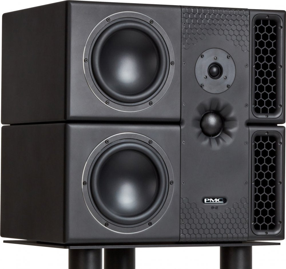 Black PMC studio monitor speaker with two large woofers and two honeycomb-patterned ports, shown stacked.