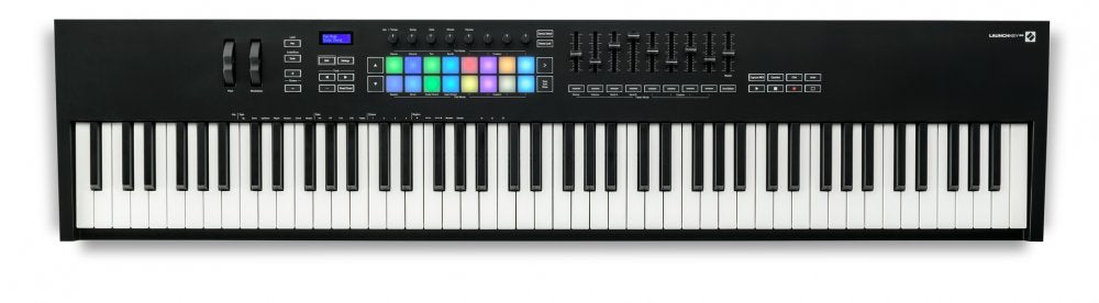 Black MIDI keyboard controller with 88 keys, colorful pads, knobs, pitch and modulation wheels, and a small display.