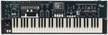 Black and white keyboard synthesizer with various knobs, sliders, buttons, wheels, and a screen in the center.