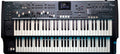 Black dual keyboard synthesizer with multiple sliders, knobs, buttons, and a small color screen on top panel.
