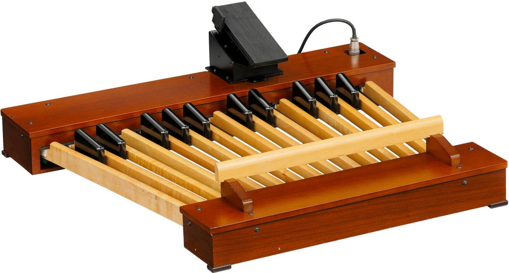 Wooden 25-note pedal board with expression pedal and attached cable on a white background.