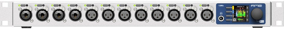 Front panel of a gray audio interface with 12 combo XLR and 1/4 inch inputs, 12 XLR outputs, meter display, and control knob.