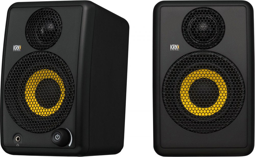 Two black studio monitor speakers with yellow speaker cones and metal mesh covers, one with a power button and headphone jack.