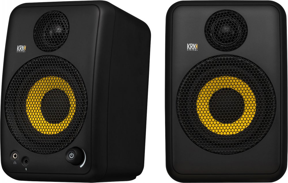 Pair of black studio monitor speakers with yellow cones and front panel controls including power button and audio jacks.