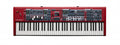 Red keyboard synthesizer with multiple knobs, faders, buttons, and display screens above the keys.