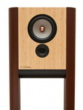 A single Grimm Audio LS1v2 active loudspeaker in natural bamboo veneer: a tall two-way monitor suspended between two curved half-cylinder side panels that form an integral two-legged floor stand, with an 8-inch woofer above a 1-inch dome tweeter on the front baffle.