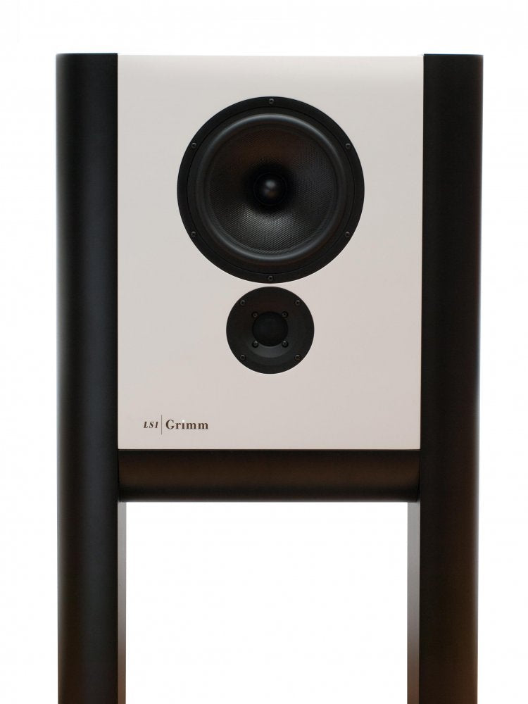 Grimm Audio LS1a active studio monitor in white lacquer: a wide, shallow two-way cabinet with a woofer and tweeter, suspended between two cylindrical legs that form its integrated floor stand.
