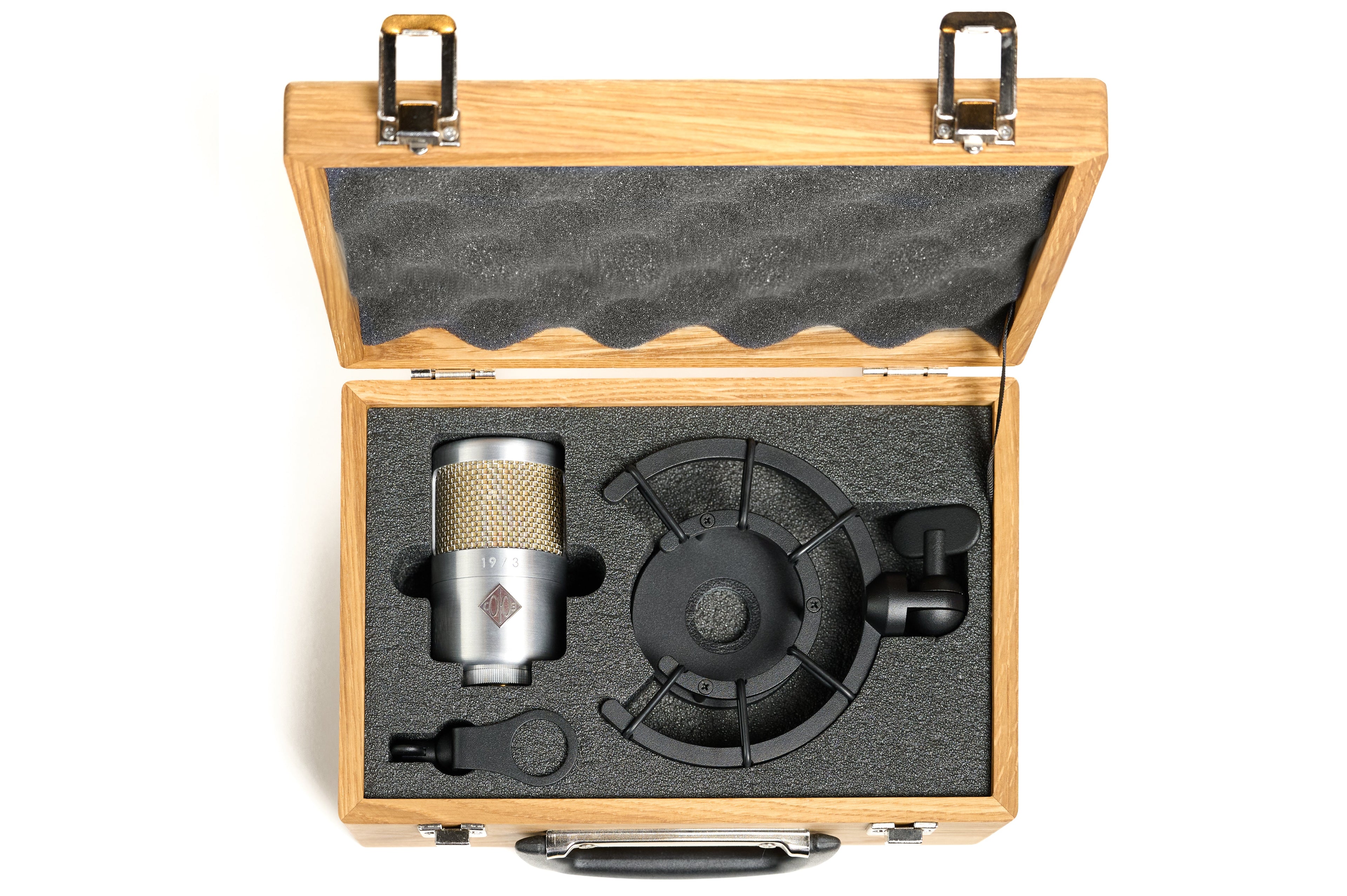 Silver microphone with shock mount and mounting adapter in a wooden case with foam padding.