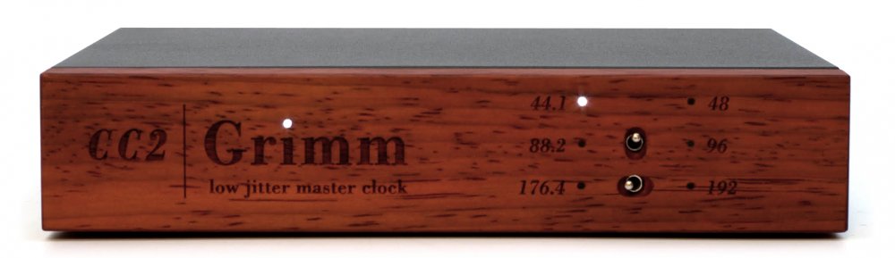 Front view of a wooden master clock device with branding and two toggle switches for frequency selection.