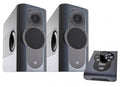 Two dark grey speakers and a black remote control with a display and control buttons.