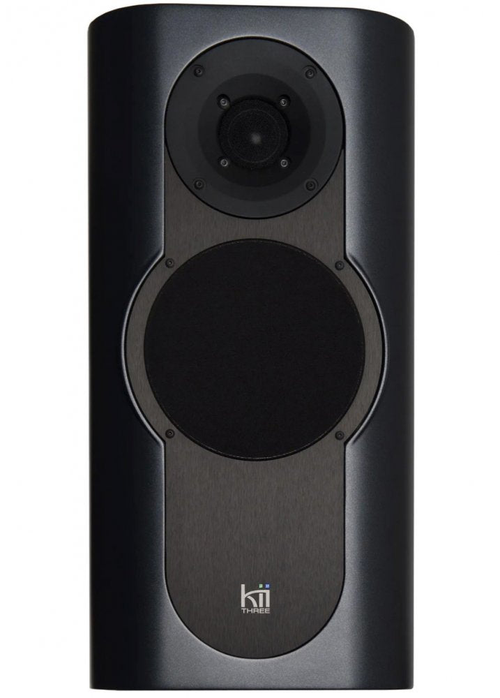 Front view of a dark grey Kii Three single speaker with fabric-covered drivers and logo visible.