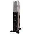 Tall dark grey and black studio monitor speaker with multiple drivers and a black stand base.