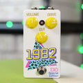 White guitar effects pedal with three yellow knobs and colorful 1982 graphic on front.