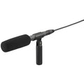 Black shotgun microphone with foam windscreen, handheld mount, and attached cable with cylindrical connector.
