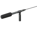 Black shotgun microphone with foam windscreen, cable, and attached handle mount on white background