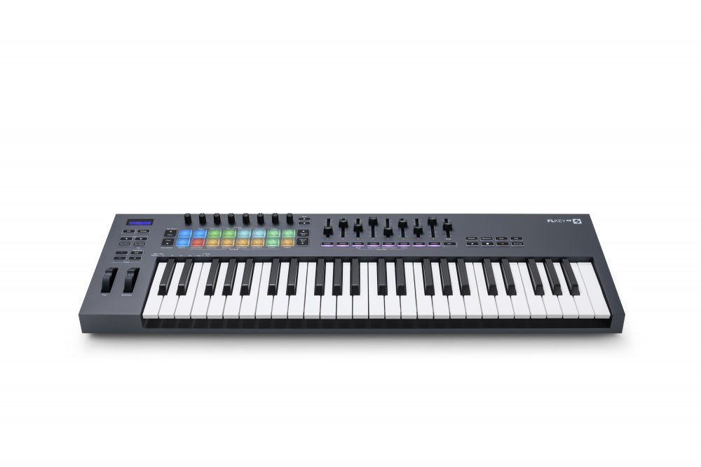 Black and white keyboard MIDI controller with 49 keys, multiple knobs, faders, colored pads, and a small display screen.