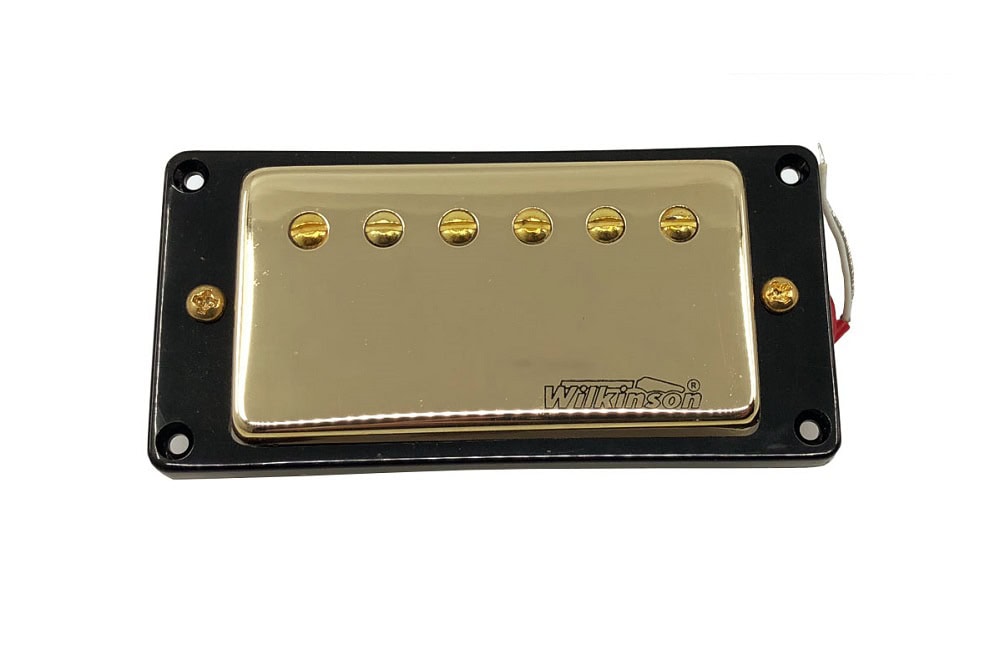 Gold-covered electric guitar pickup with black frame and visible wire leads on the side.