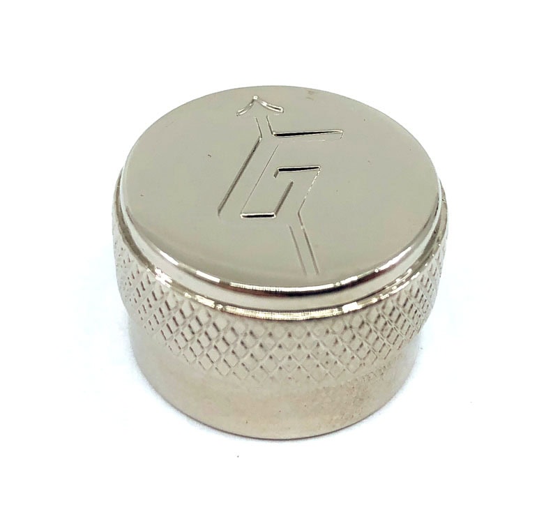 Close-up of a chrome metal knob with a textured grip and engraved logo on top.