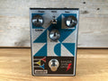 Silver and black guitar effects pedal with blue geometric design, three knobs, a toggle switch, and a footswitch.