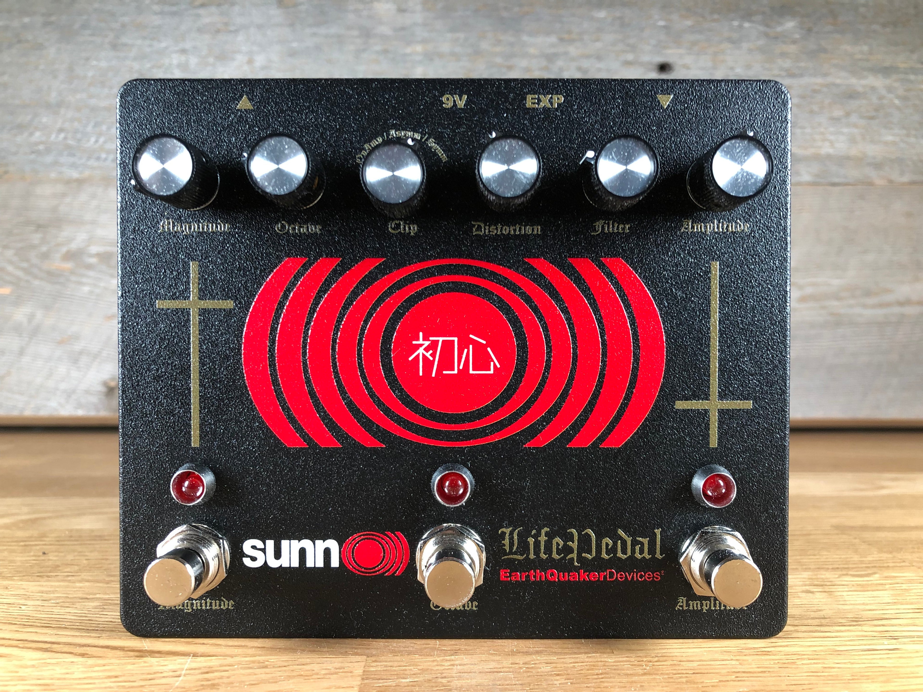 Black guitar effects pedal with six knobs, three footswitches, red LED indicators, and red circular graphic with white text.