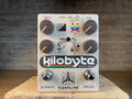 Silver guitar effects pedal with four black knobs, two footswitches, and colorful pixel art graphics.