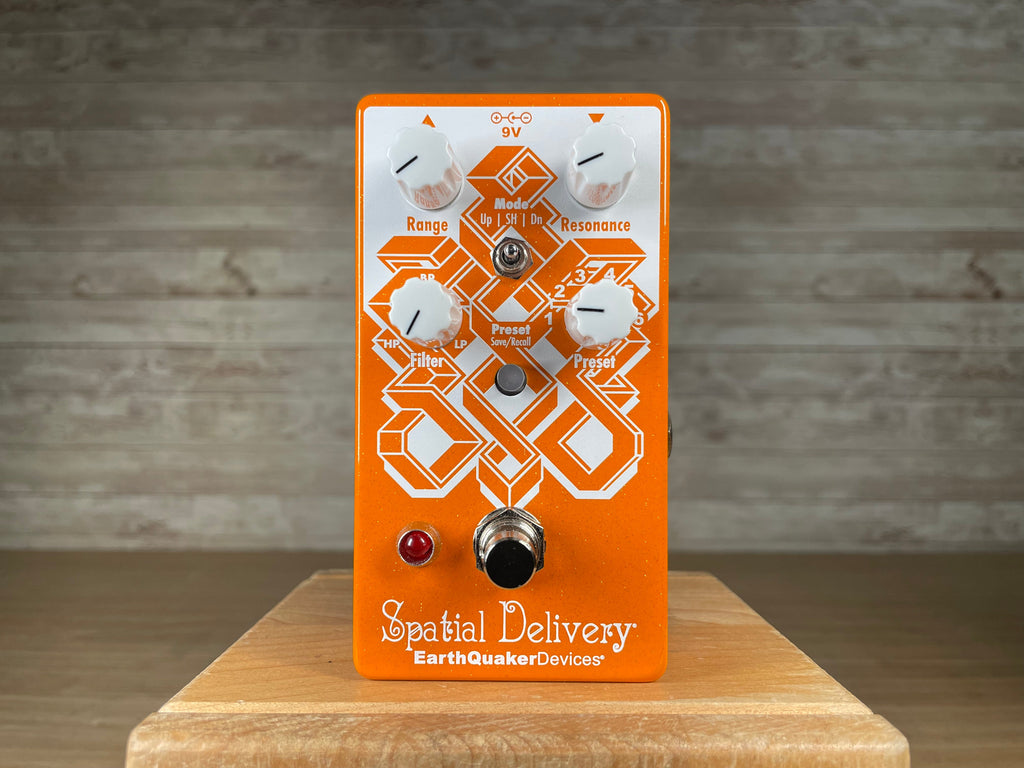 Orange guitar effects pedal with four knobs, toggle switch, footswitch, and red indicator light on front face.