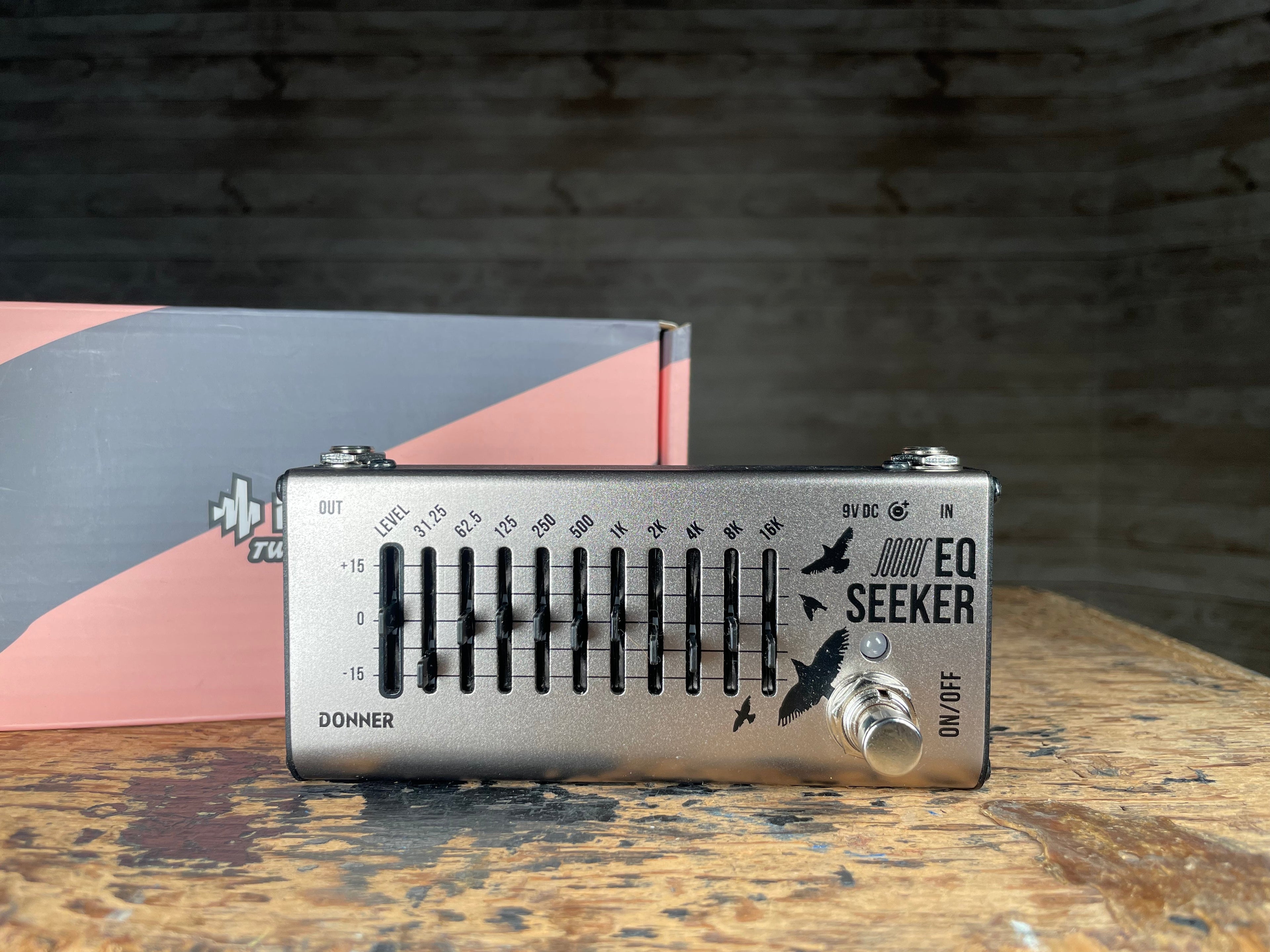 Silver Donner EQ Seeker 10-band equalizer pedal with sliders, footswitch, and original box behind it.