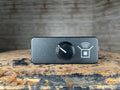 Small black rectangular pedal with a single black knob and a white icon on front panel.
