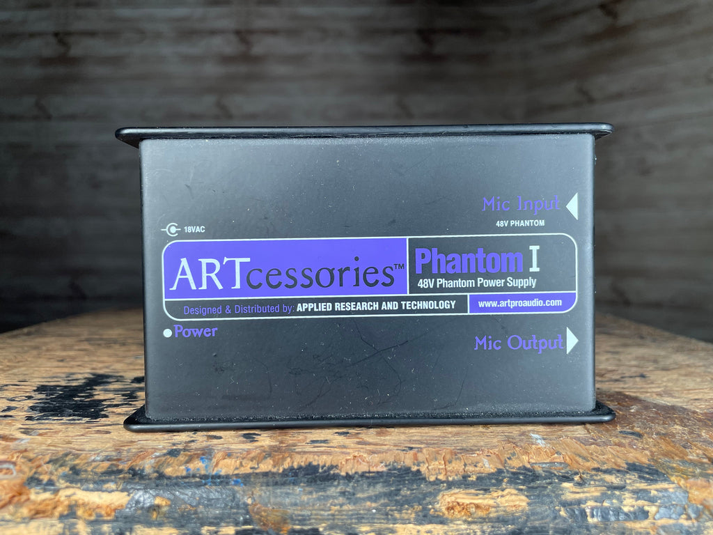 Black rectangular ART Phantom I 48V phantom power supply with labeled mic input and output connections.