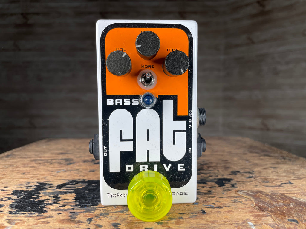 White and orange guitar effects pedal with three knobs, toggle switch, and blue LED on a wooden surface.