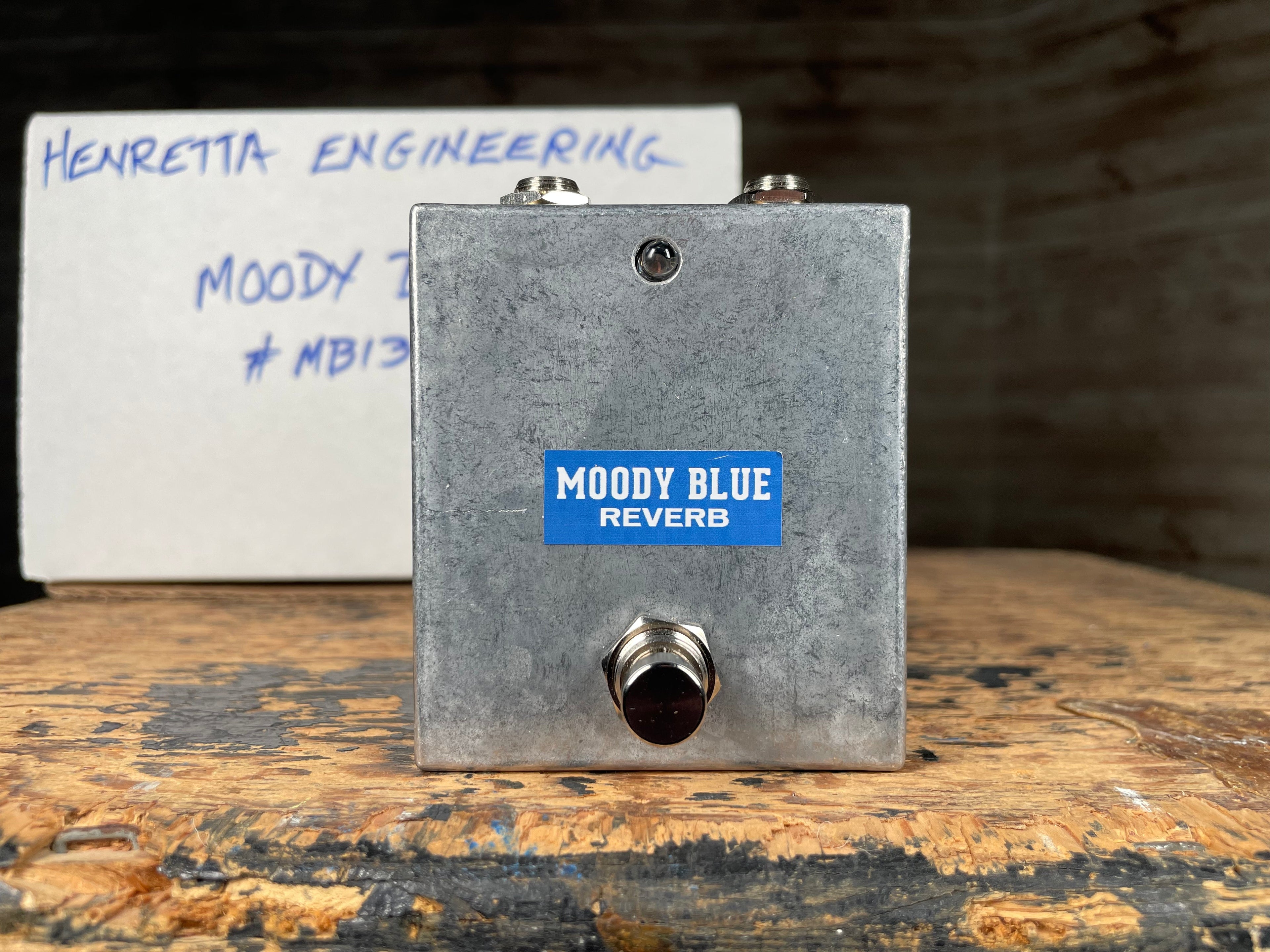 Rectangular metal guitar effects pedal labeled Moody Blue Reverb with a footswitch and two 1/4 inch jacks on top.